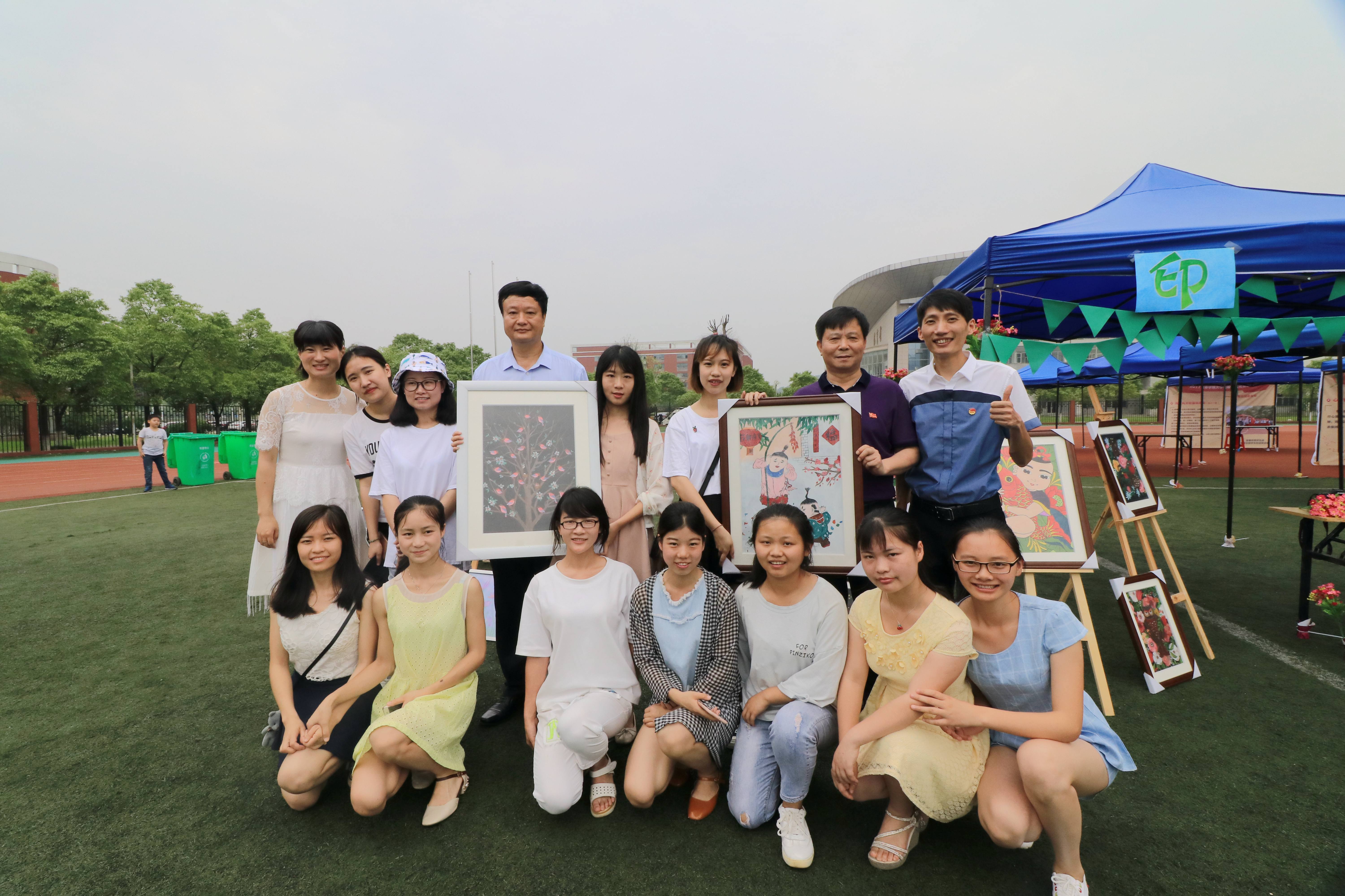 校领导参观大学生创意展示台,并与参加活动的大学生合影